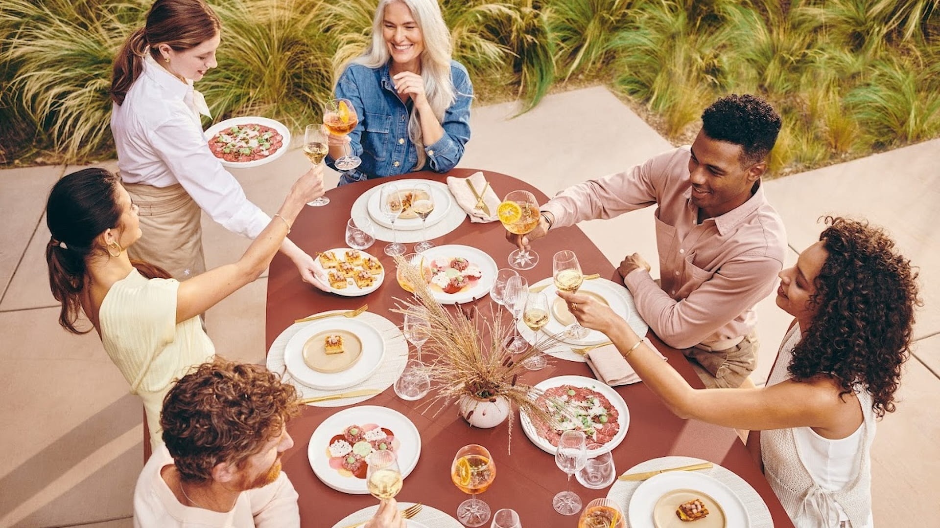 Friends enjoying outdoor meal and drinks together.