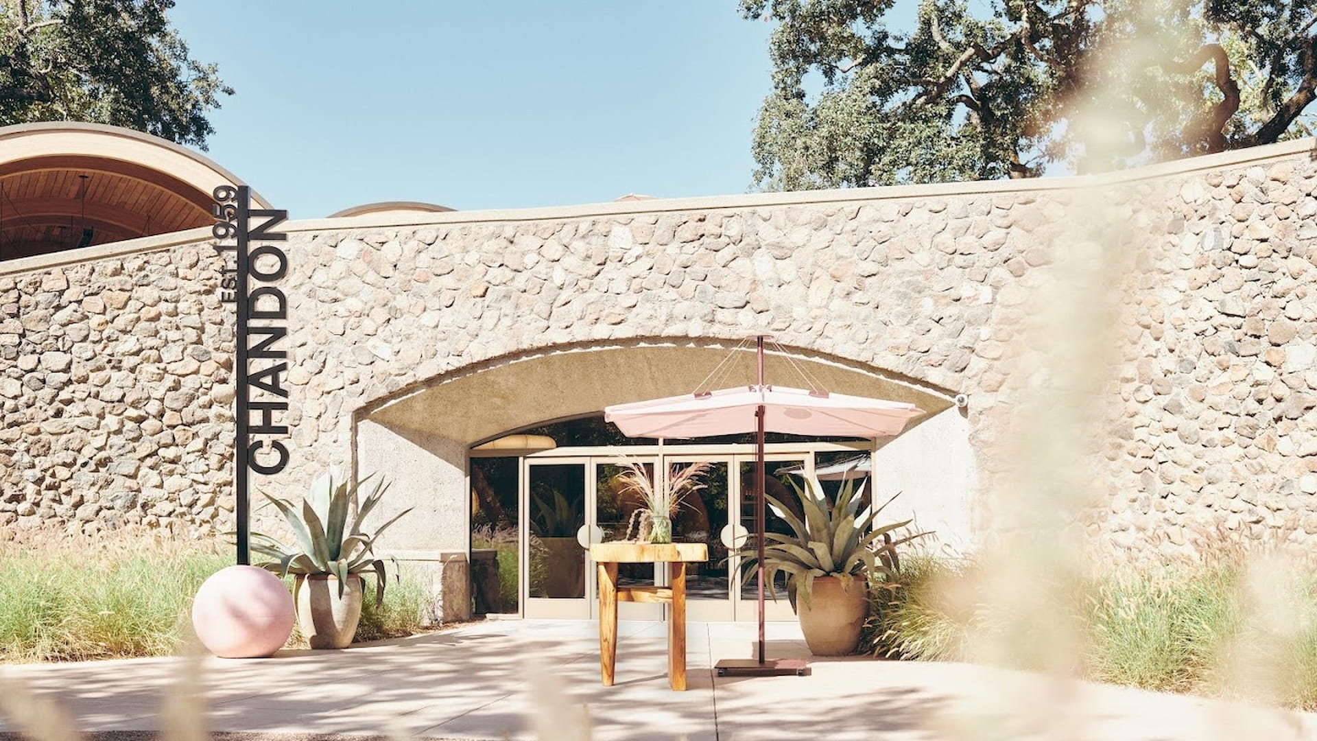 Chandon winery entrance with stone wall and plants.