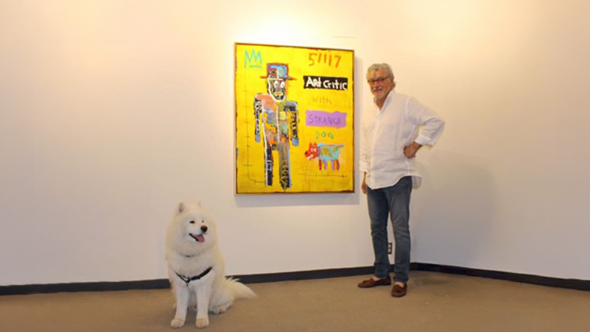 Man and white dog beside colorful gallery painting