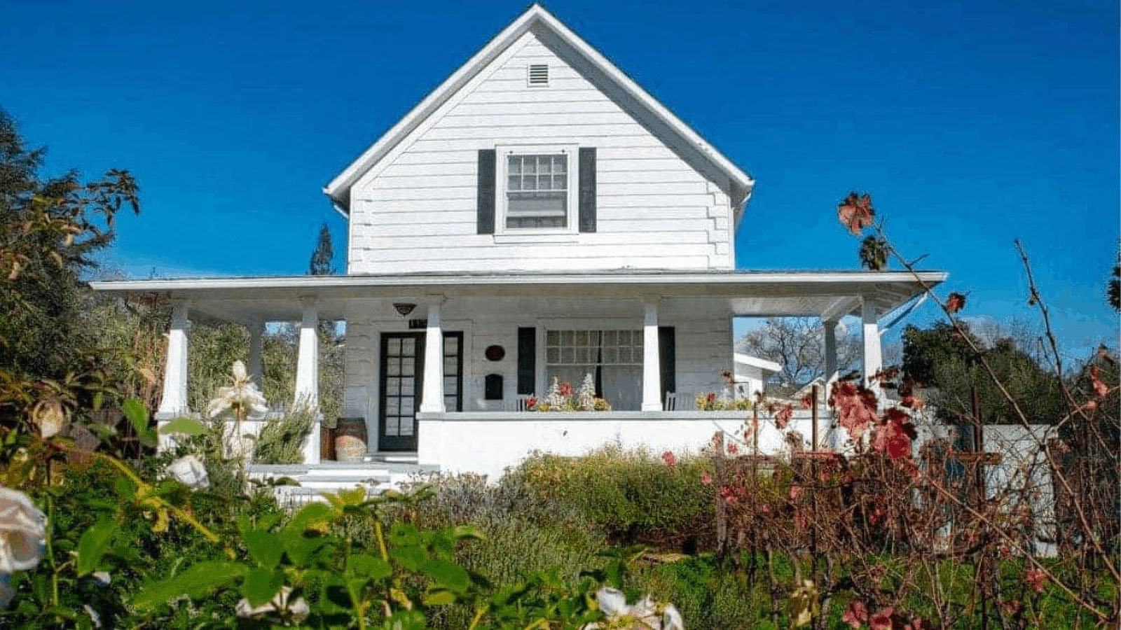 White house with porch and garden