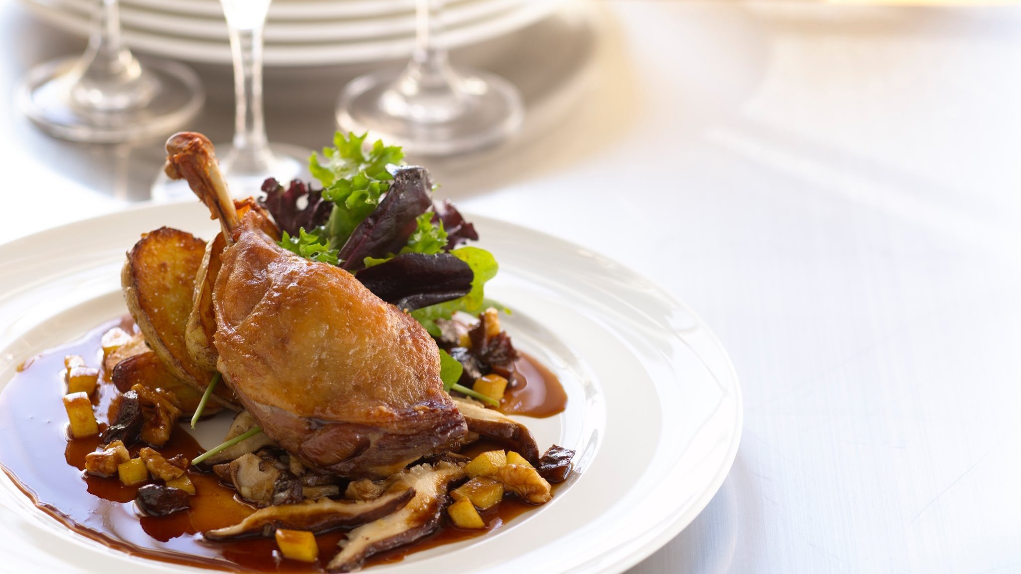 Roasted duck with potatoes and salad on plate
