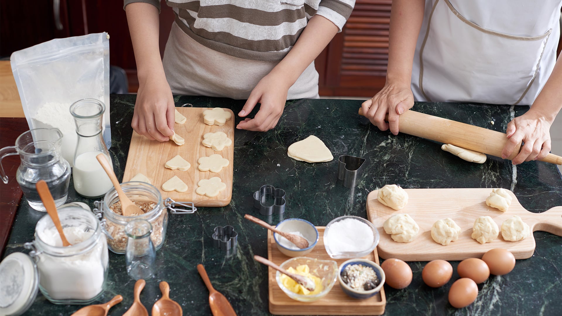 Two people baking and cutting cookie dough
