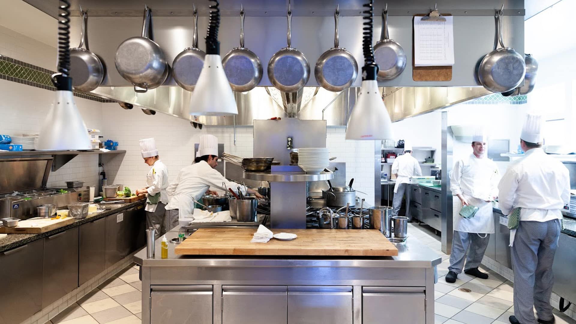 Busy professional kitchen with chefs preparing meals.