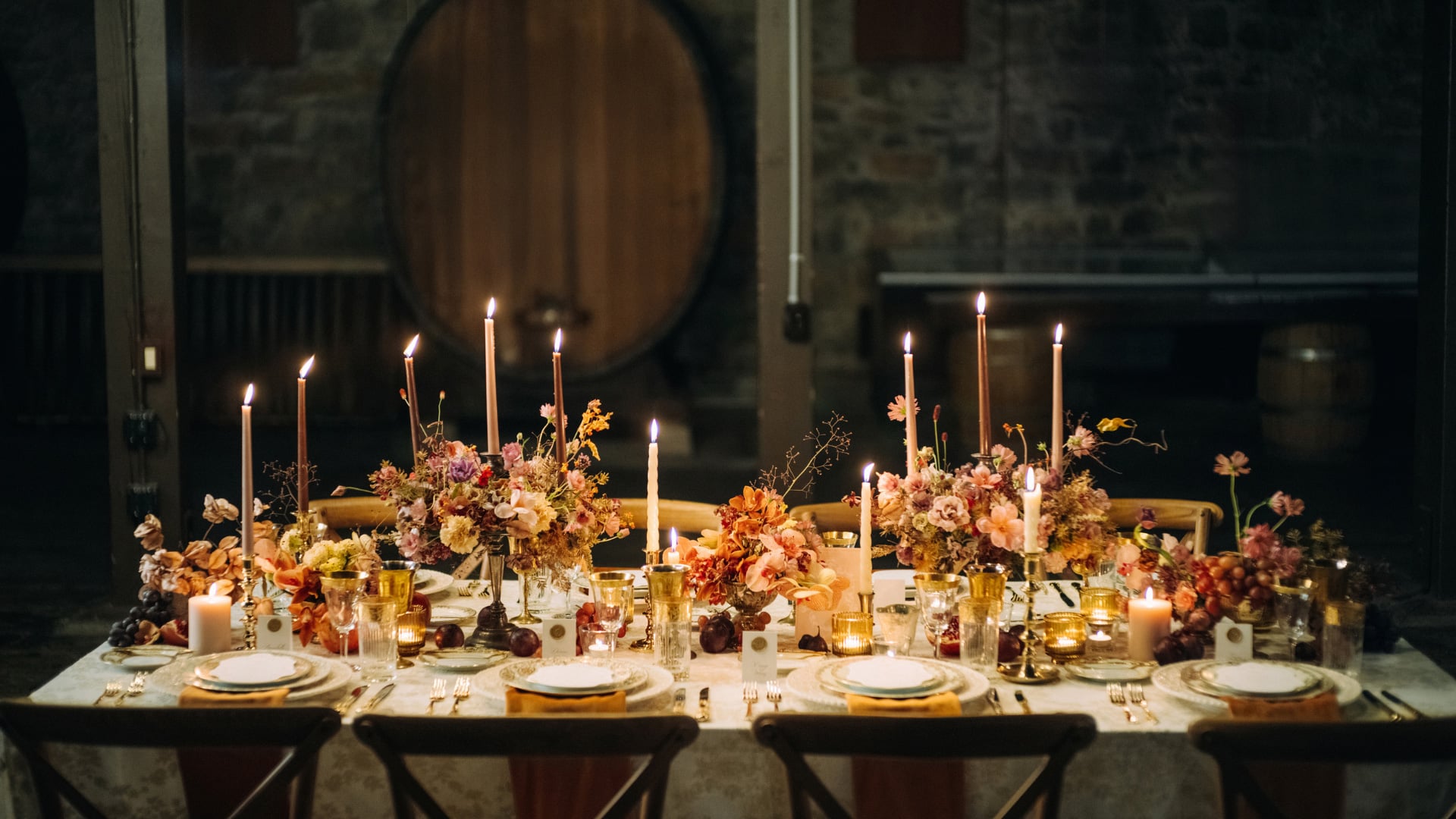 Candlelit table with floral centerpieces and gold place settings