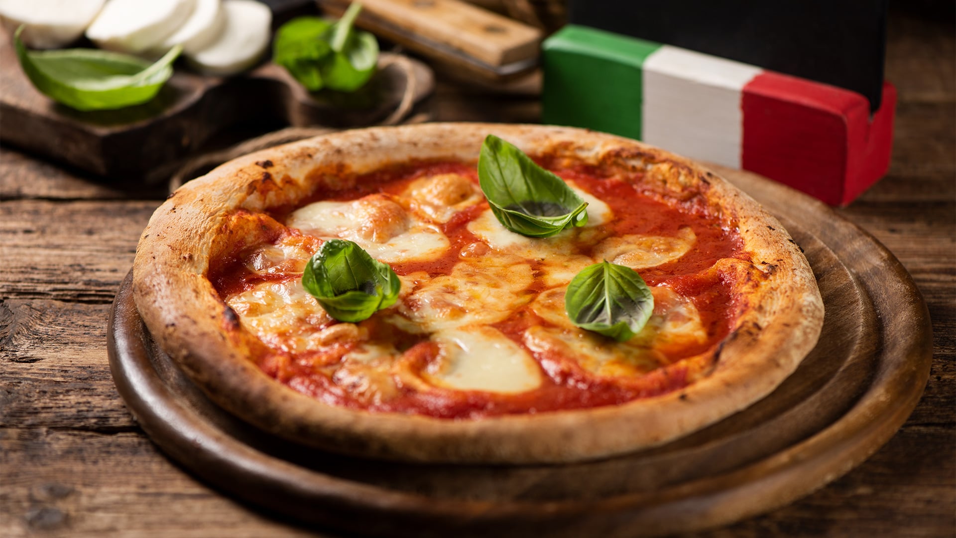 Margherita pizza with basil on a wooden board