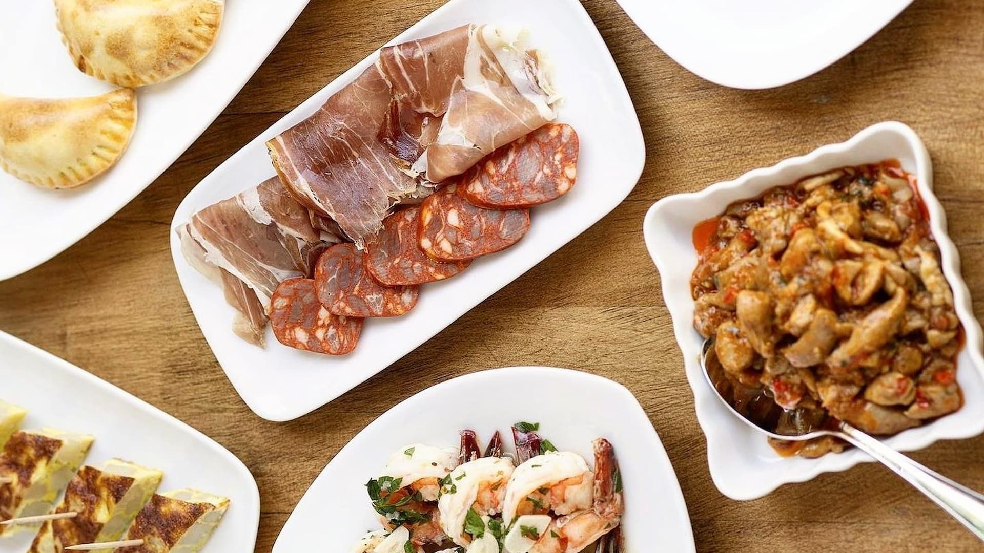 Assorted Spanish tapas on white plates