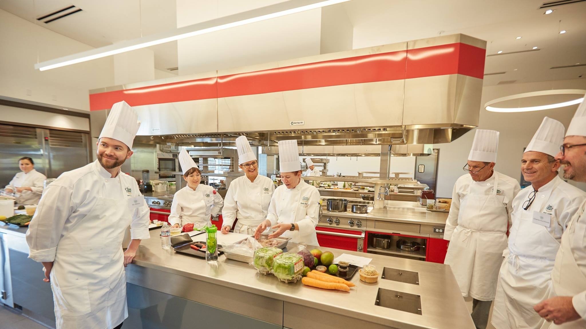 Chefs in a classroom kitchen setting.