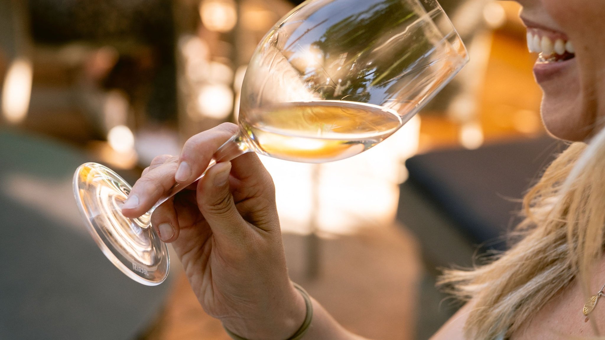 Woman tasting white wine in bright setting