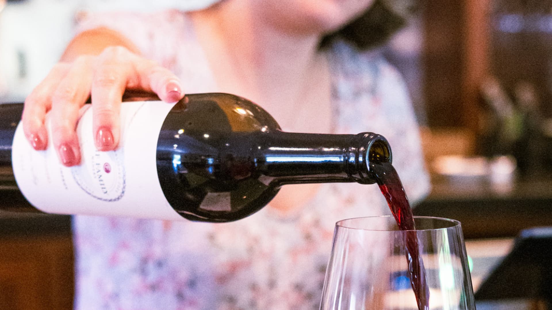 Person pouring red wine into a glass