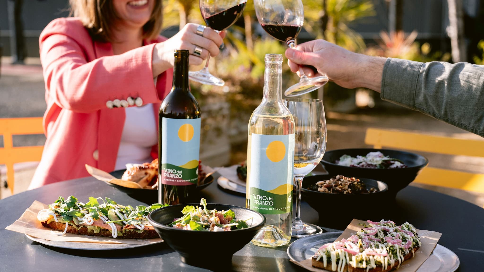 Friends toasting wine at outdoor lunch table