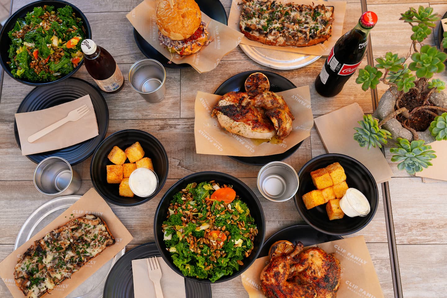 Overhead table with chicken, salads, flatbreads, drinks