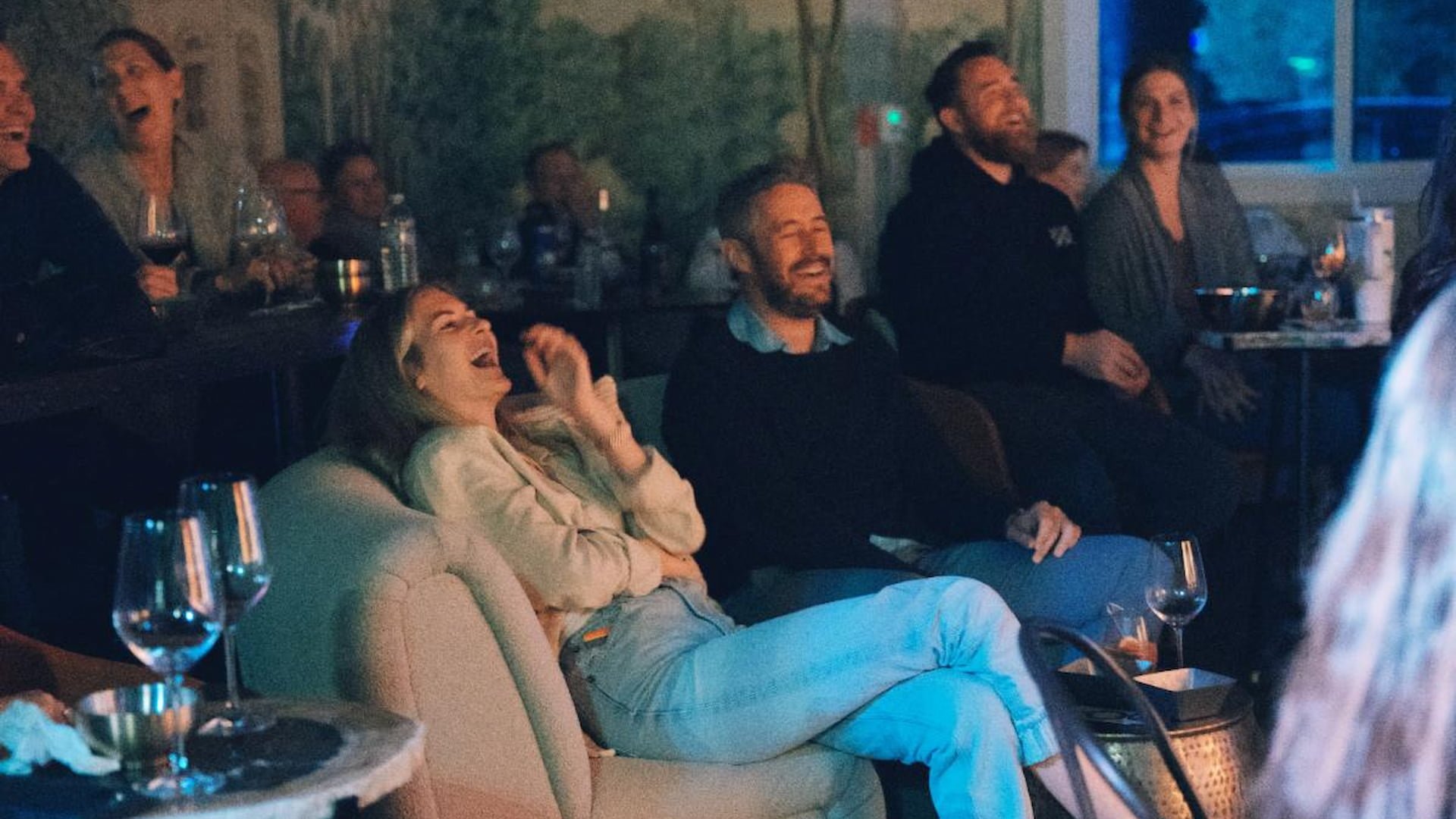 People laughing together at a comedy show