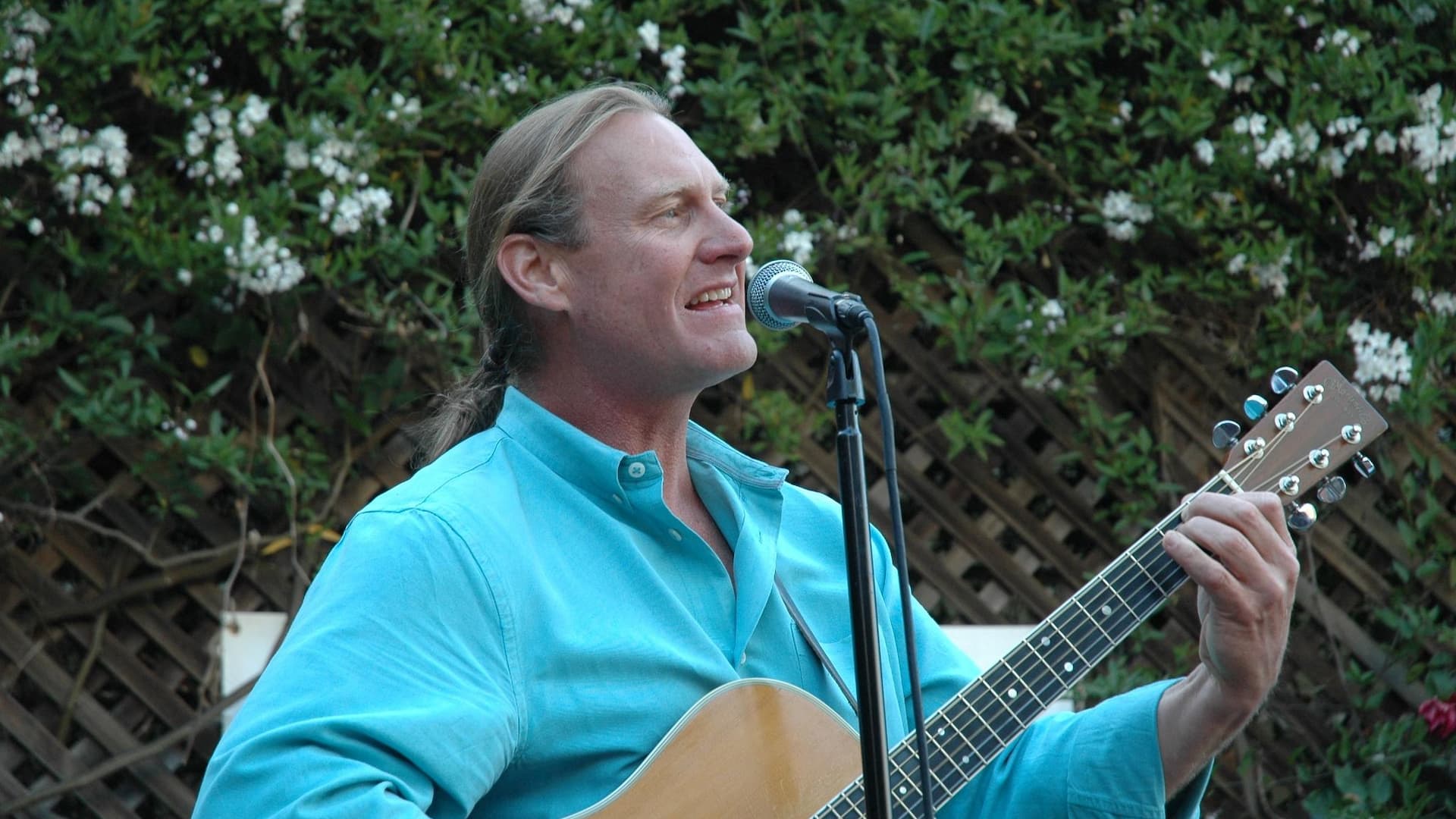 Person singing with guitar outdoors