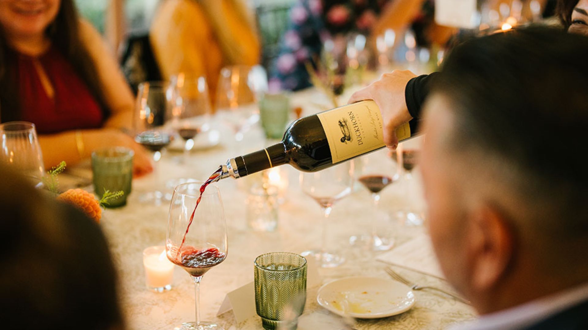 Red wine being poured at dinner table