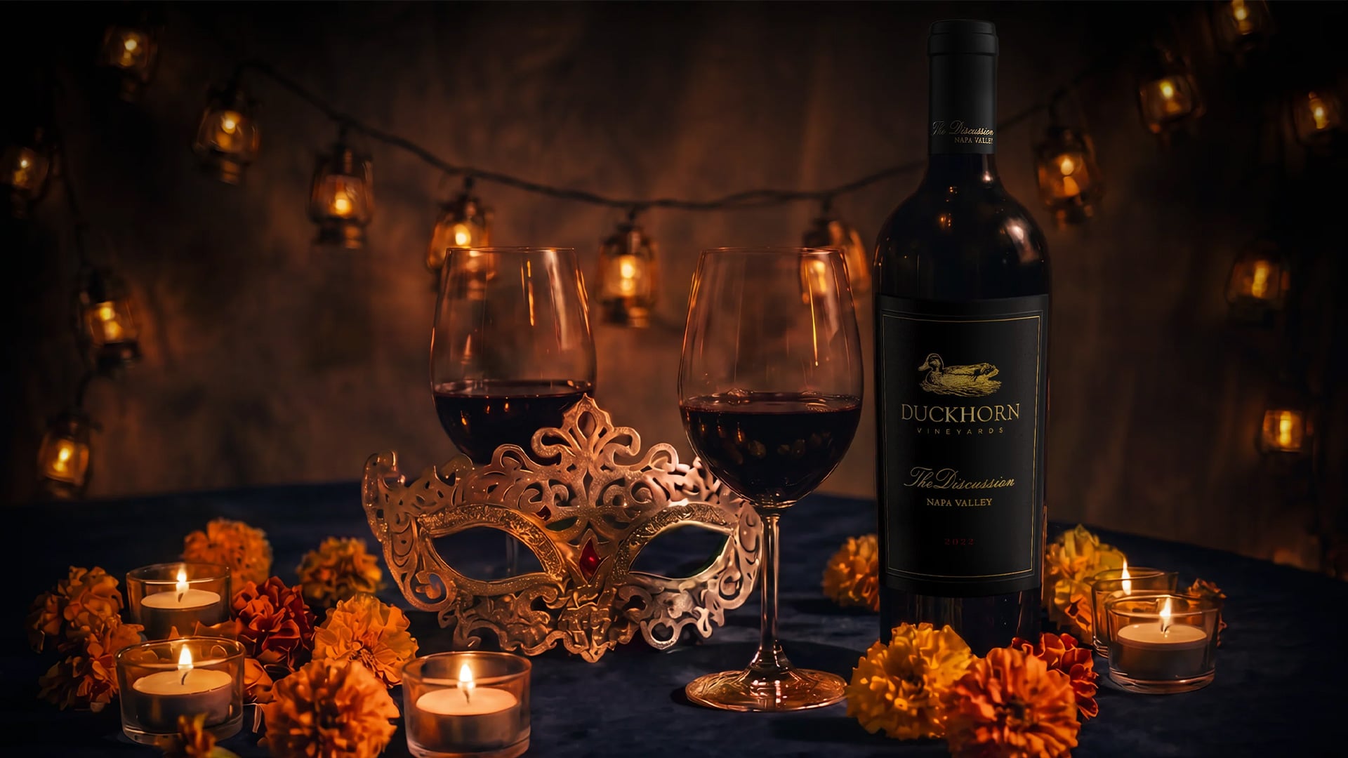 Duckhorn red wine, glasses, mask, candles, and marigolds