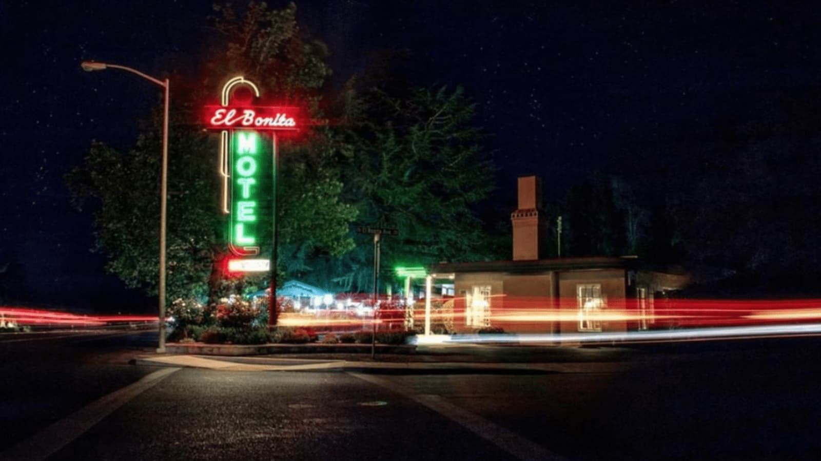 Neon motel sign glowing at night.