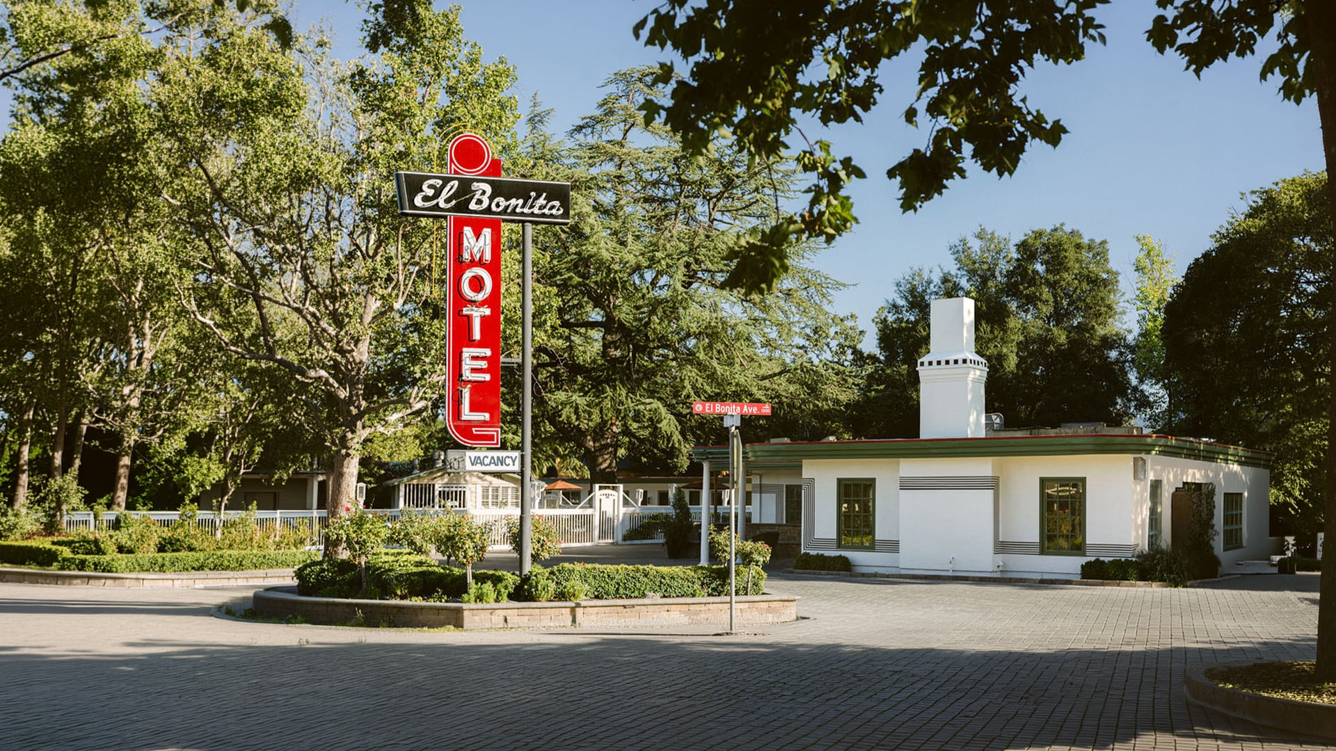 Vintage El Bonita Motel sign beside white office building