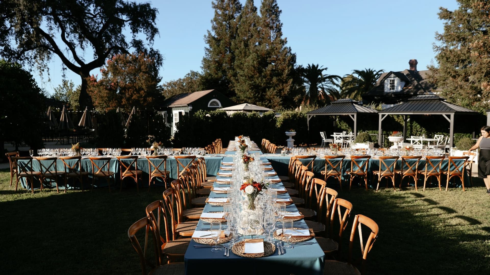 Outdoor banquet setup with decorated tables and chairs.