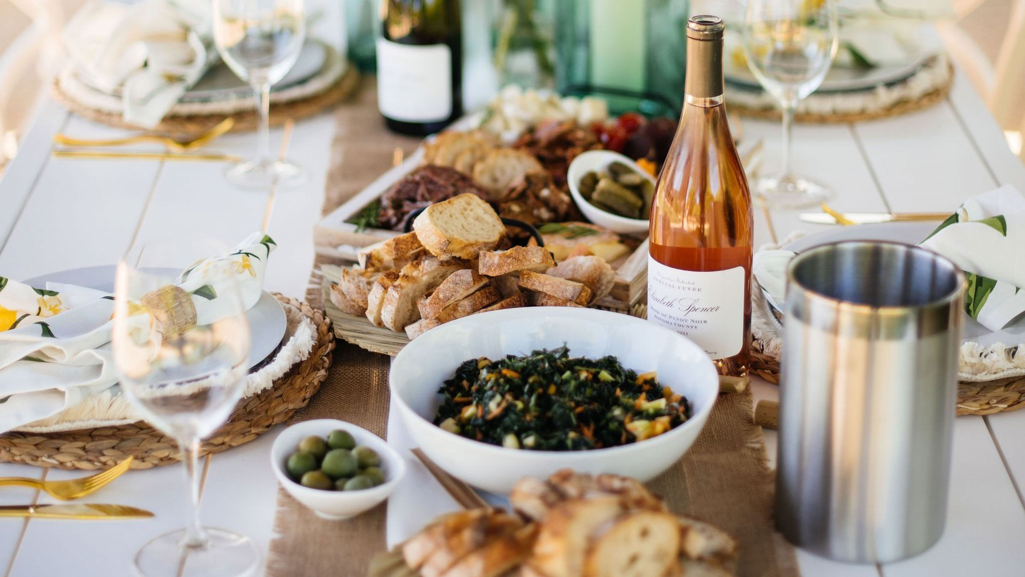 Gourmet table with wine, bread, and salad.