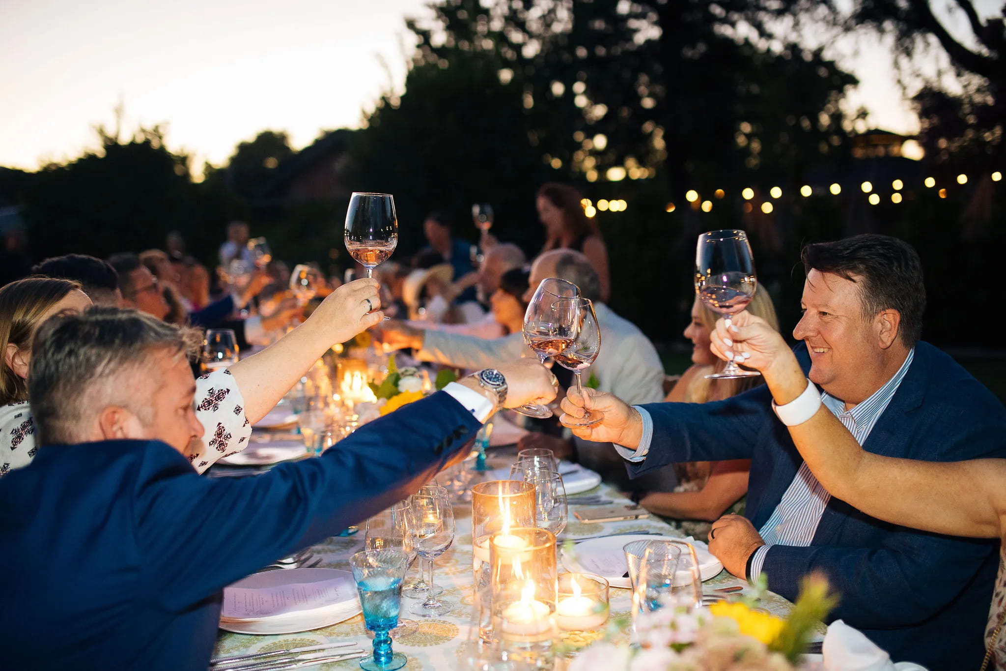 Group toasting at outdoor dinner table
