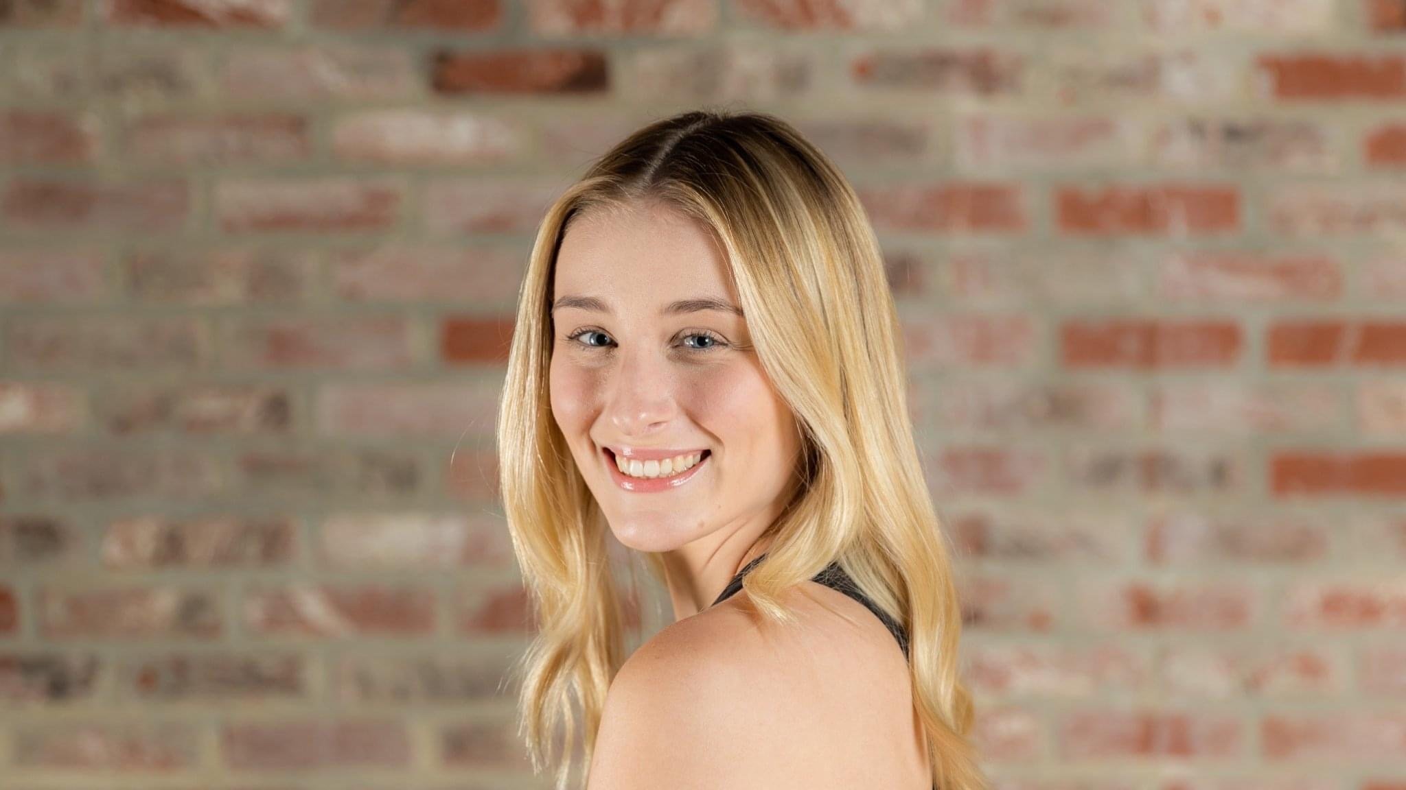 Smiling person against brick wall background