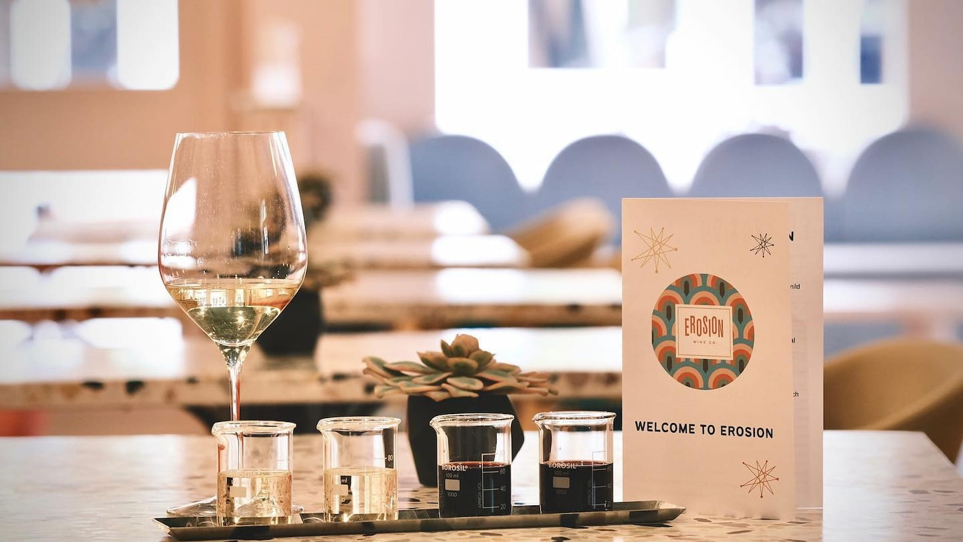 Wine glass and menu on a restaurant table.