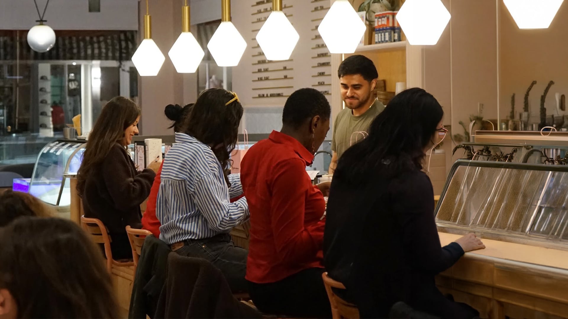 Customers seated at a warmly lit café counter