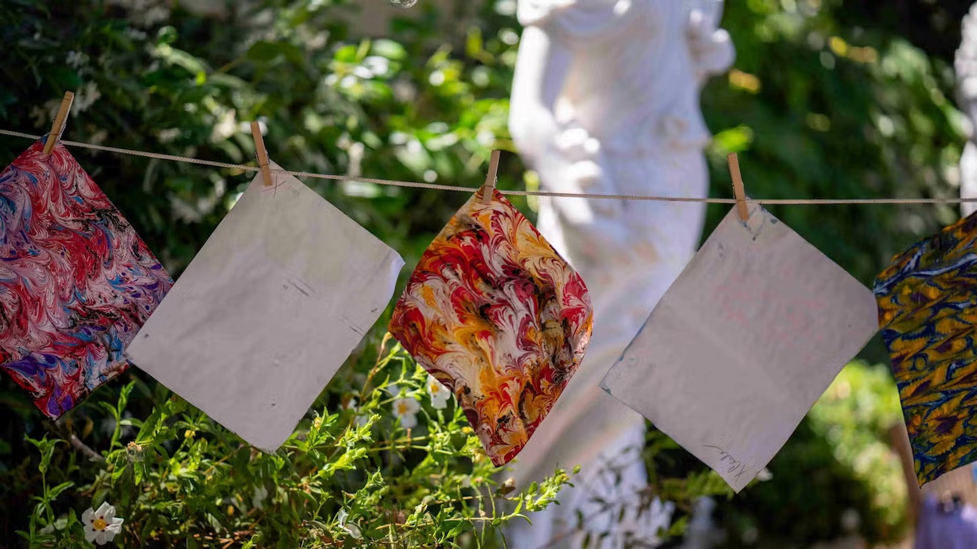 Marbled art papers hanging on outdoor clothesline