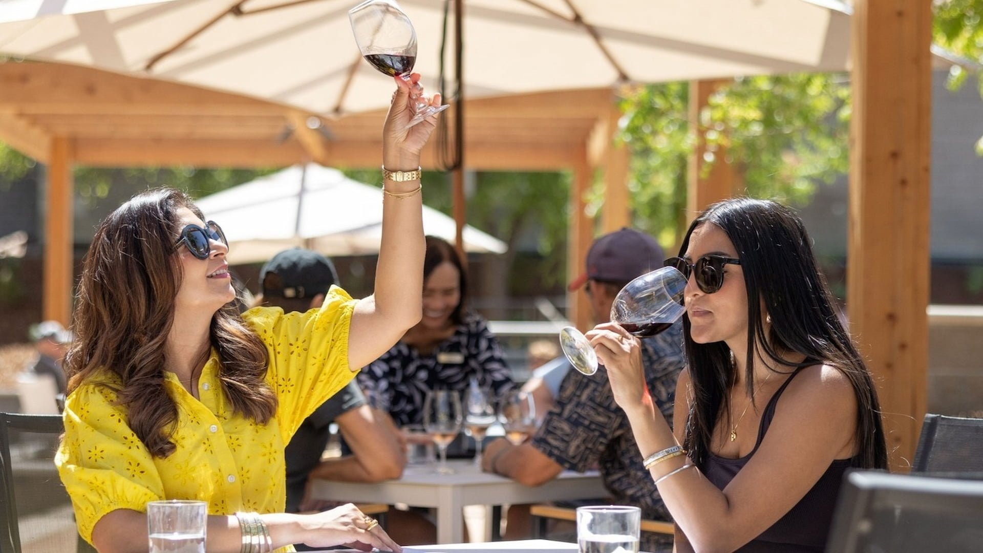 Women enjoying wine outdoors at a patio