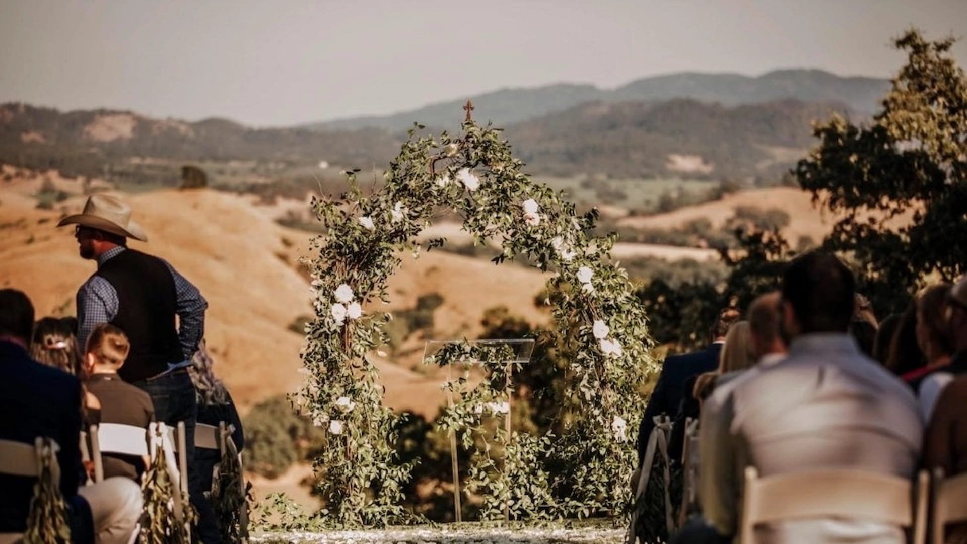 Outdoor wedding ceremony with scenic mountain backdrop.