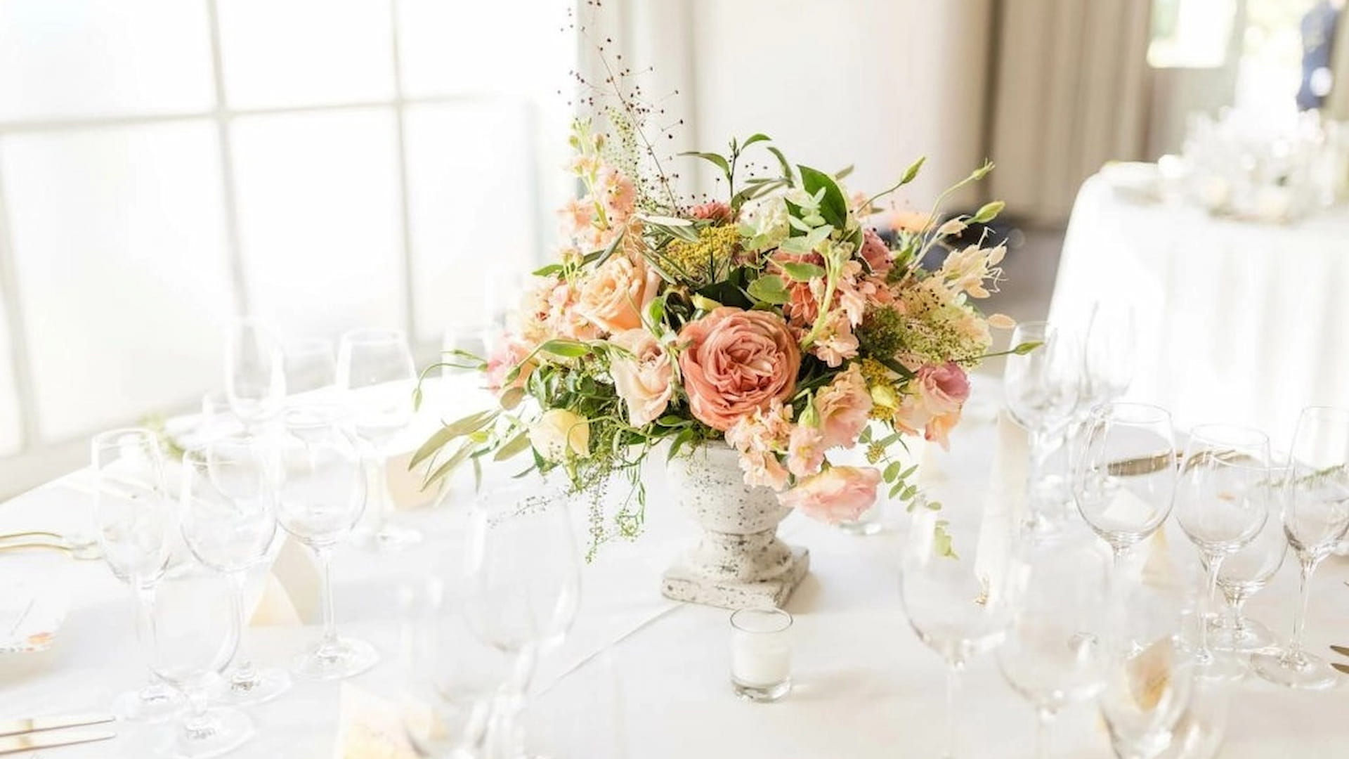 Elegant floral centerpiece on wedding table setting.