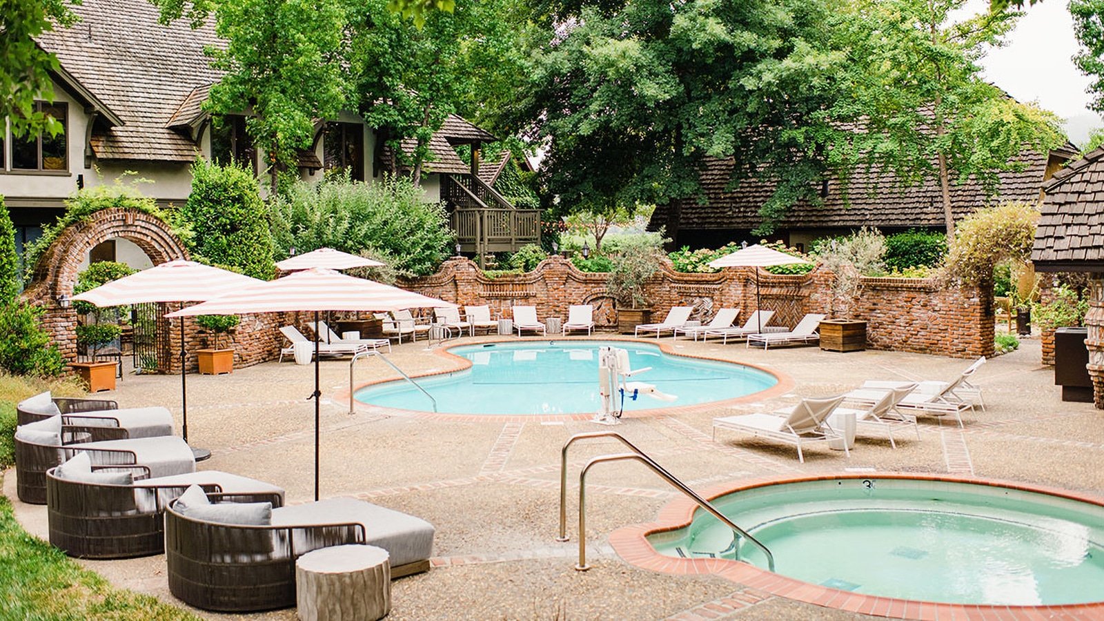 Cozy hotel pool with chairs and umbrellas.