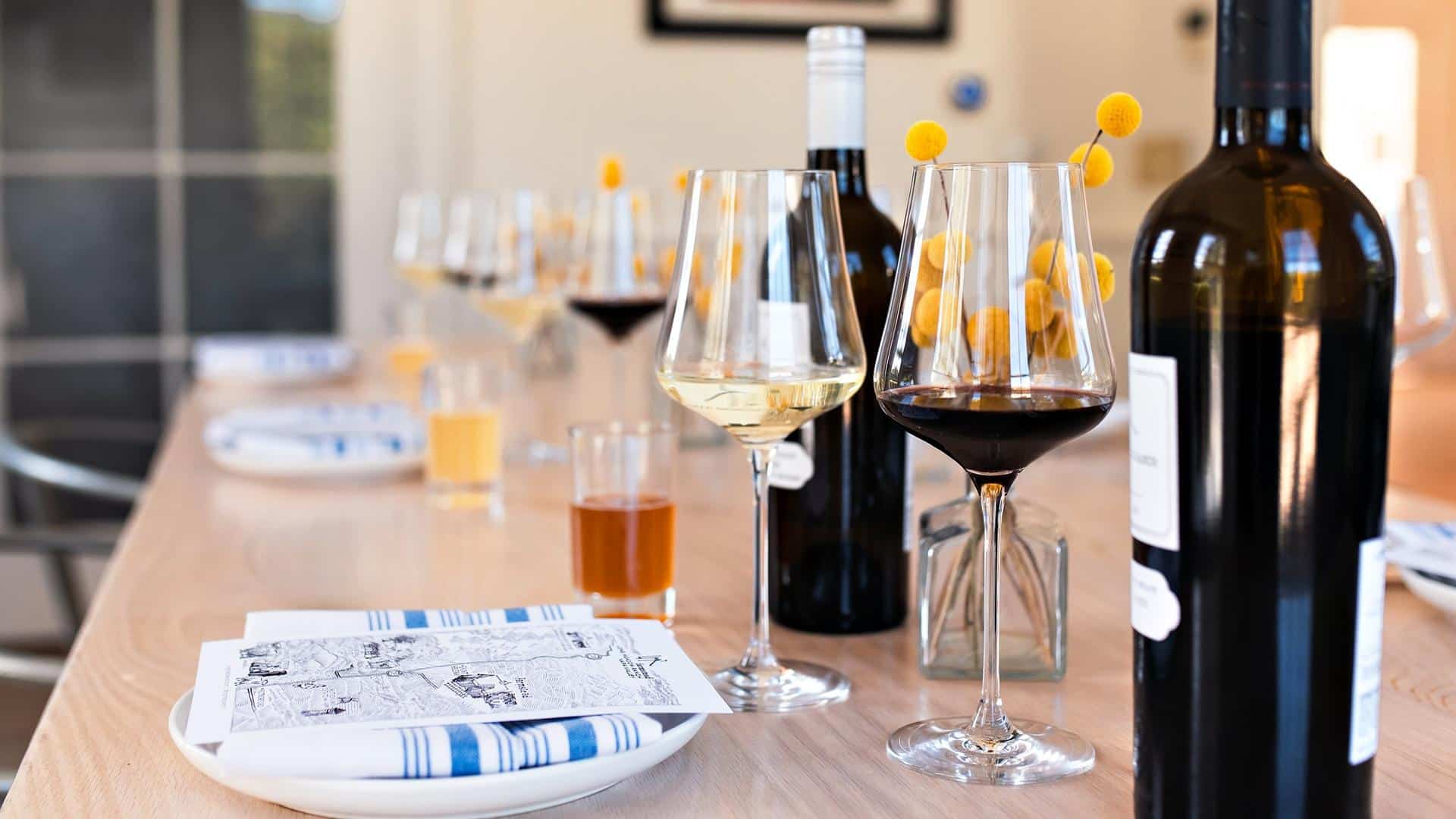 Table setting with wine glasses and bottles.