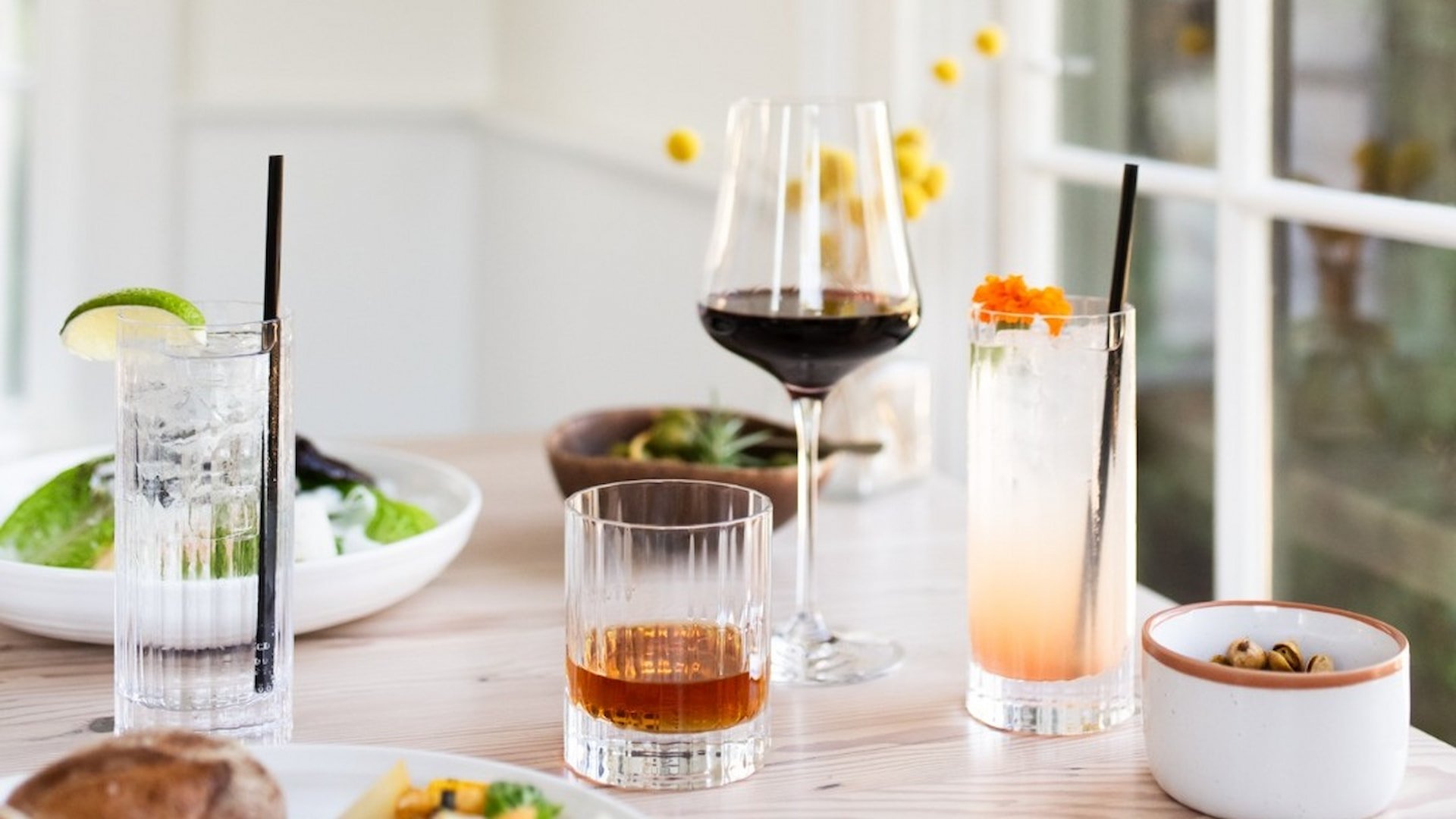Assorted drinks and snacks on a wooden table.