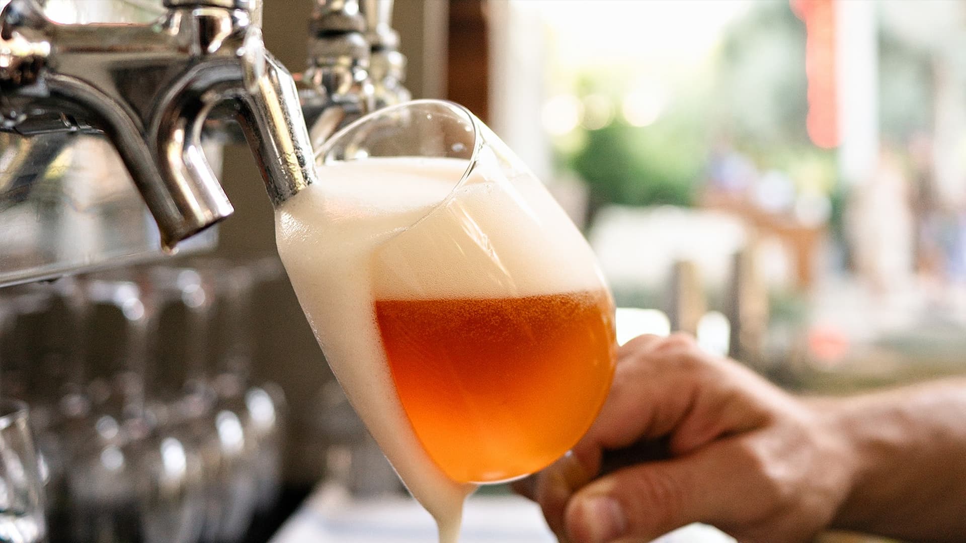 Beer poured from tap into tilted glass