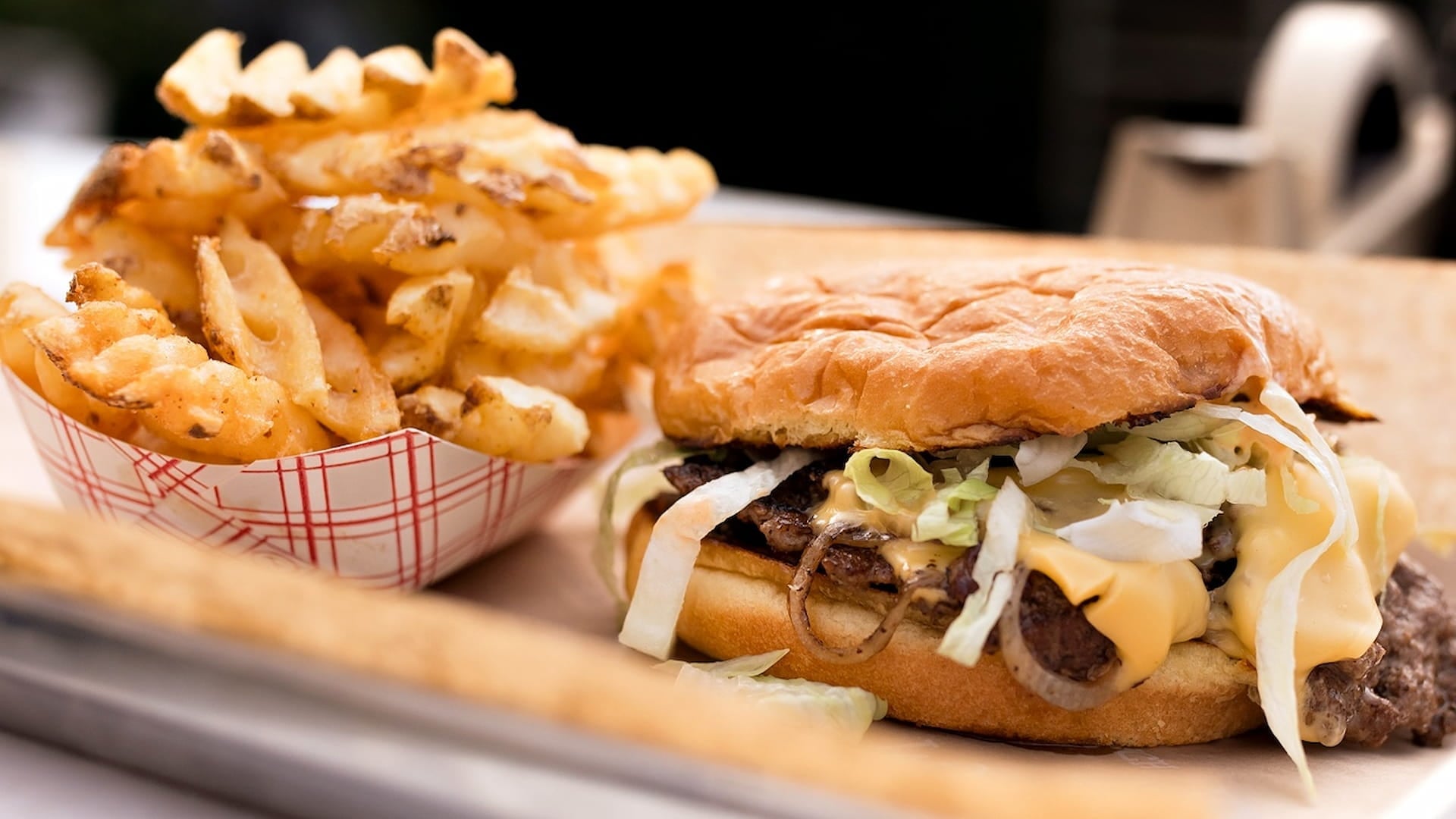 Cheeseburger with lettuce and waffle fries
