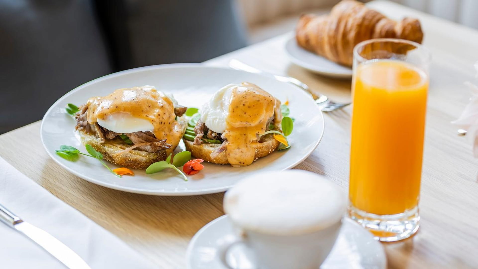 Breakfast with eggs benedict and orange juice