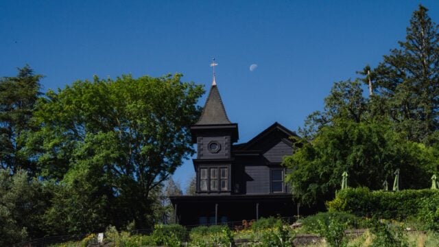 Victorian house with turret under blue sky.