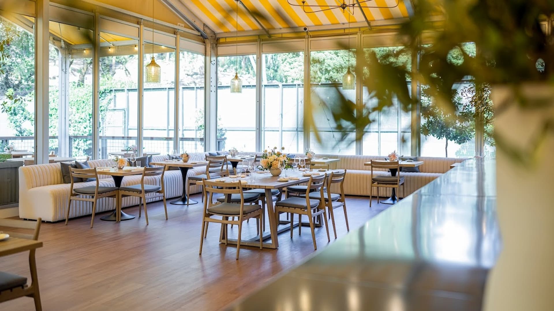 Modern restaurant interior with wooden tables and chairs.