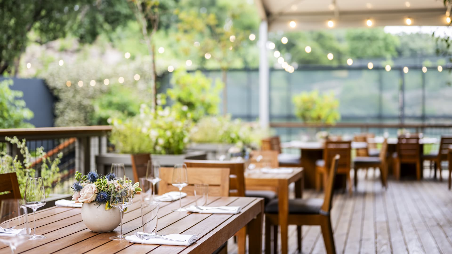 Outdoor dining area with wooden tables and chairs.