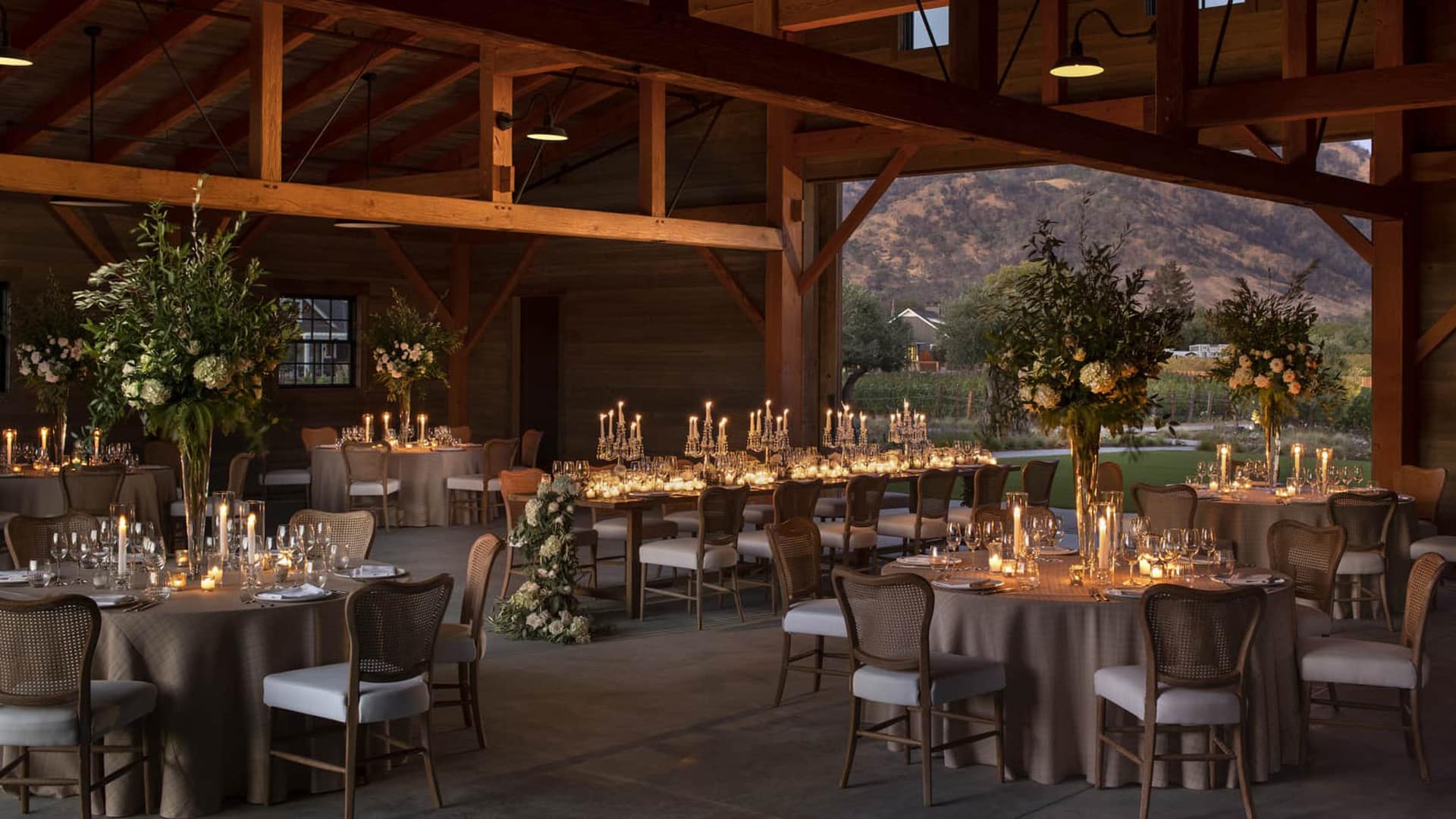 Elegant wedding reception with candlelit tables and flowers.