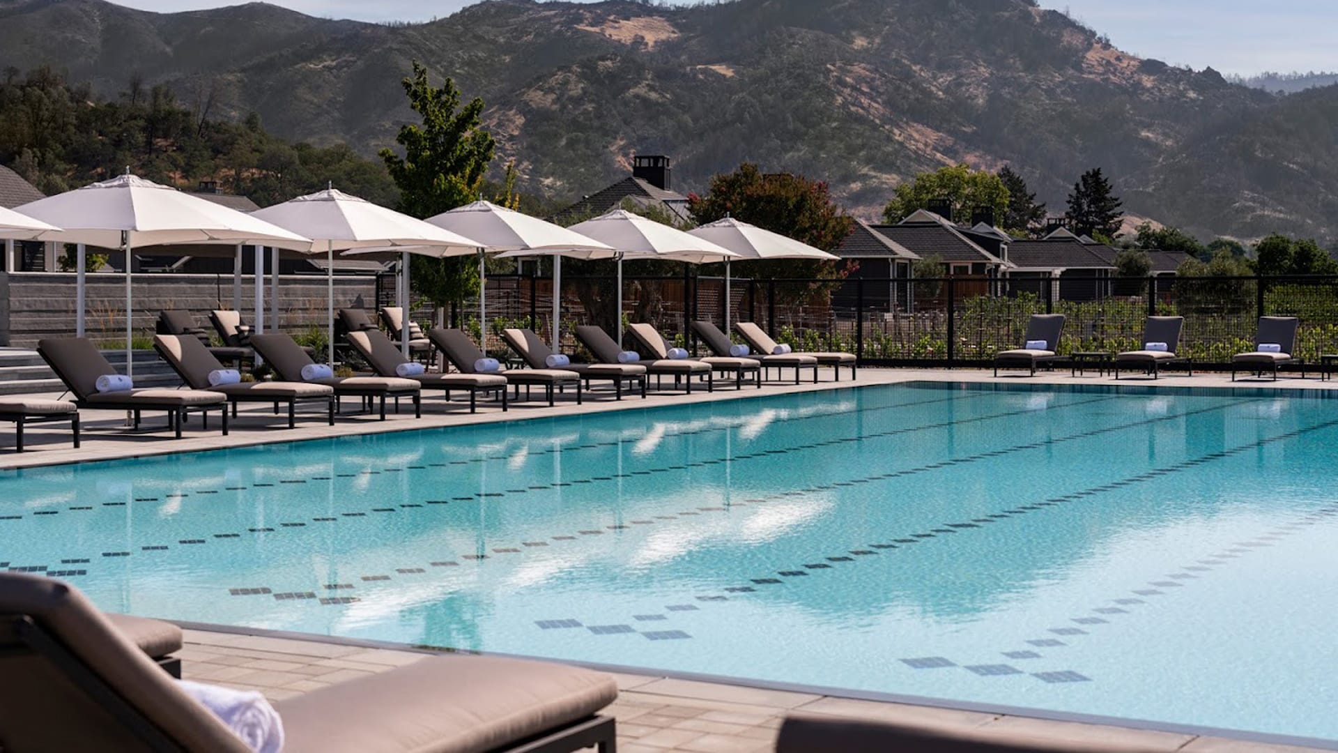 Outdoor pool with lounge chairs and mountain view.
