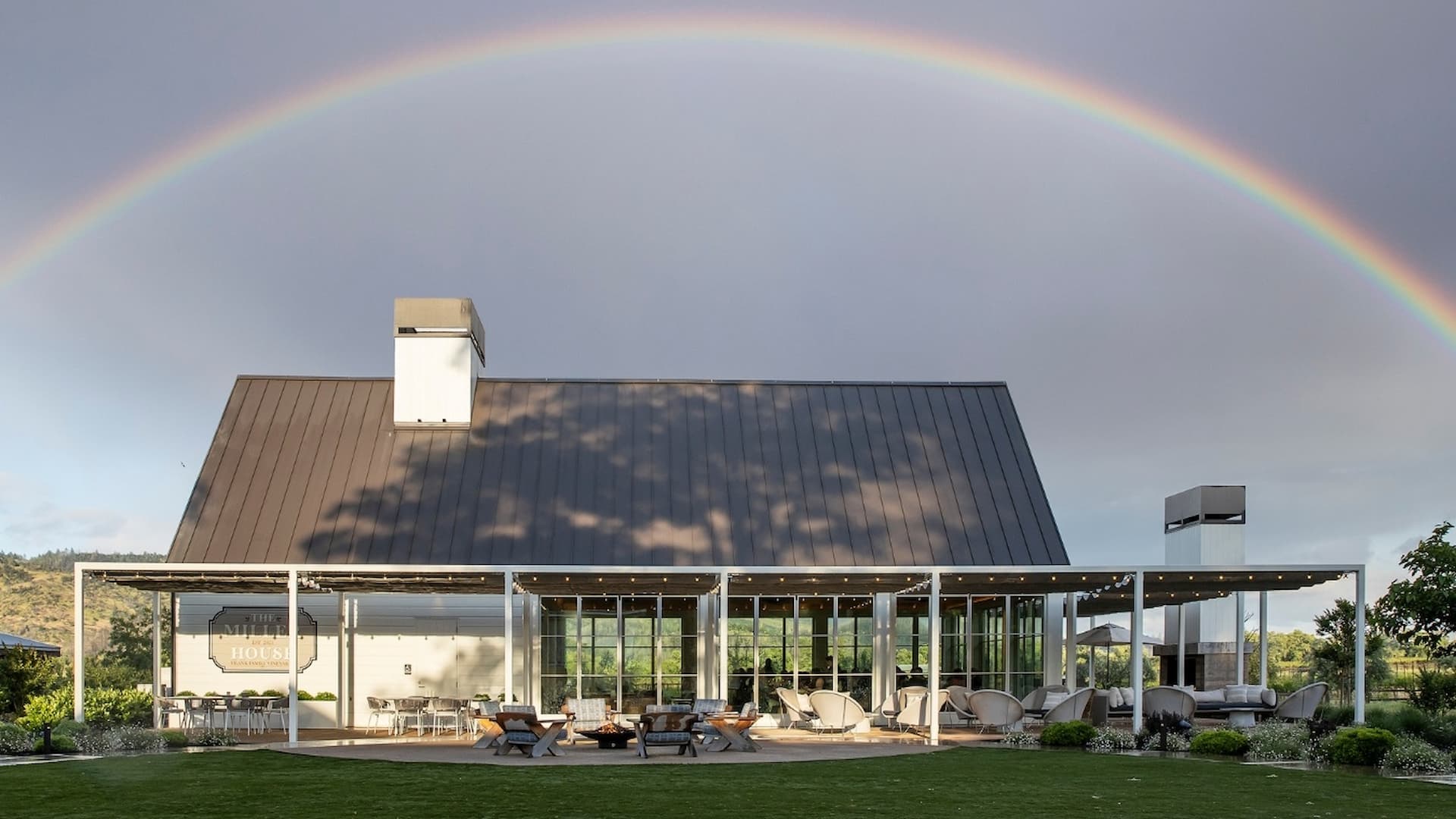Modern building with rainbow in sky.