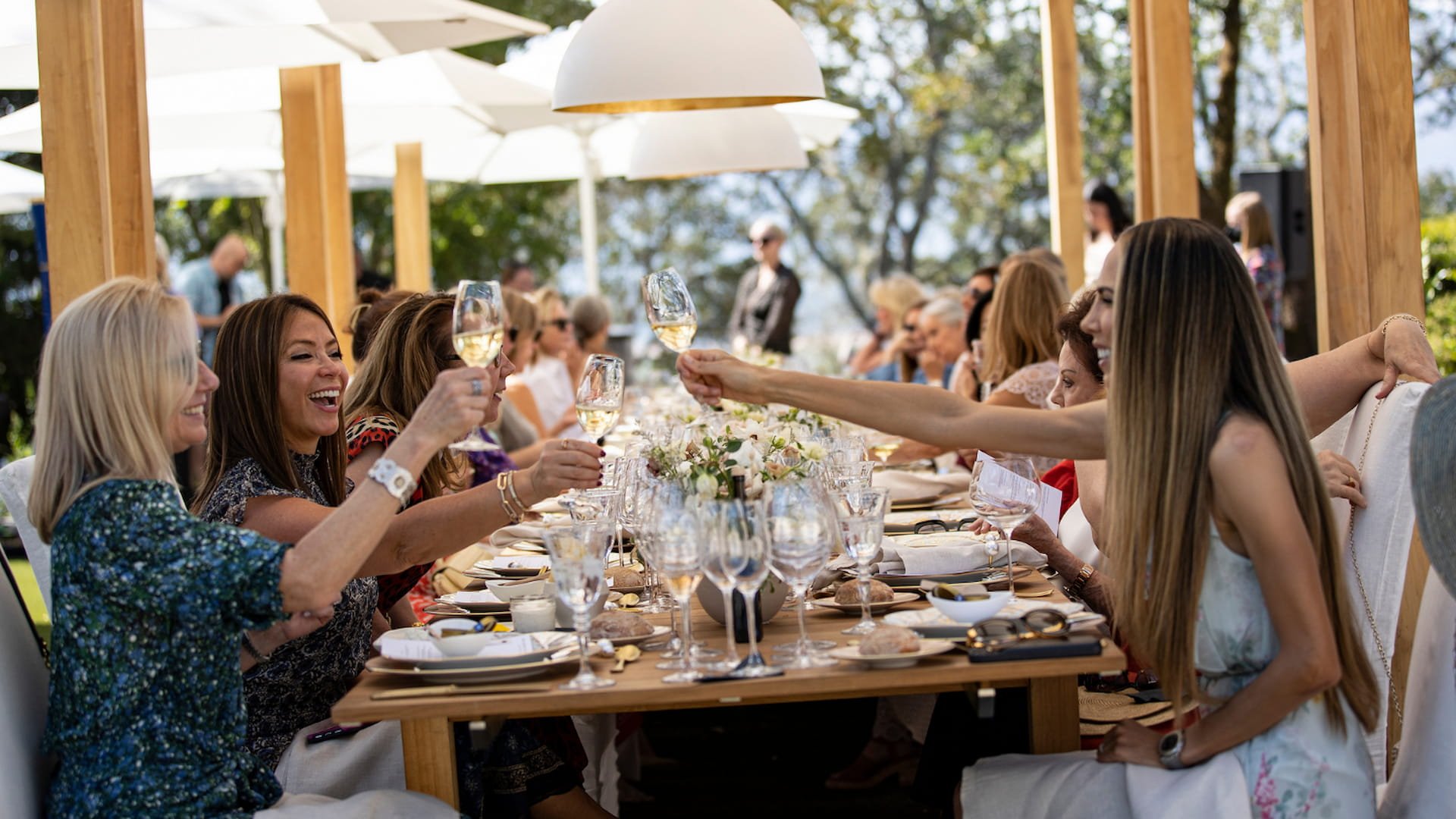 Friends toast at outdoor dining event.