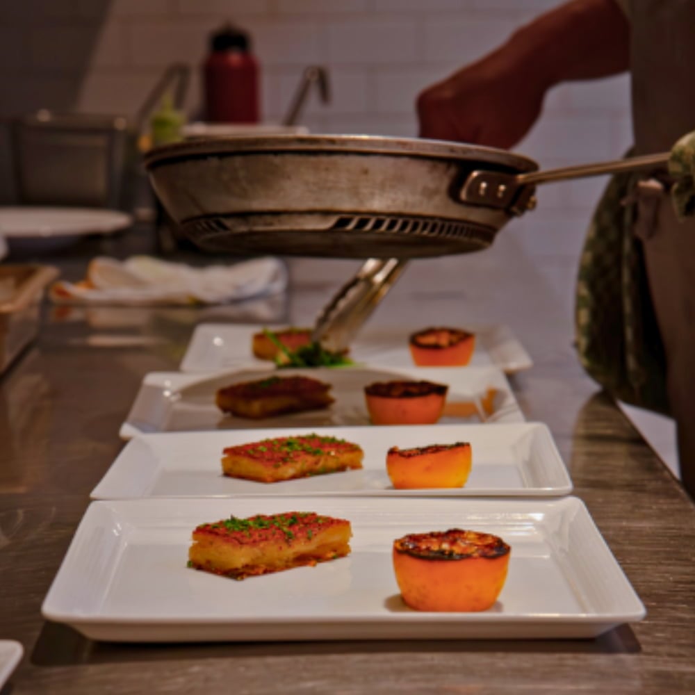 Chef plating gourmet dishes in restaurant kitchen