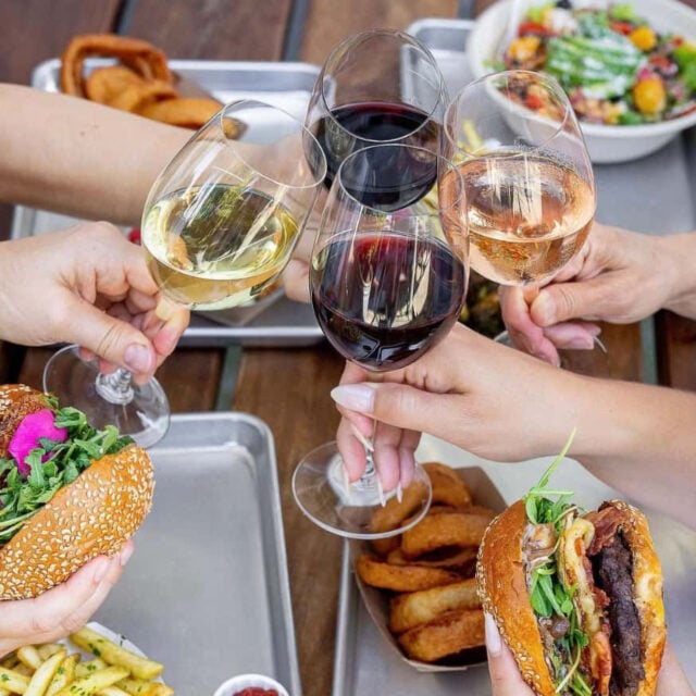 People toasting with wine and burgers