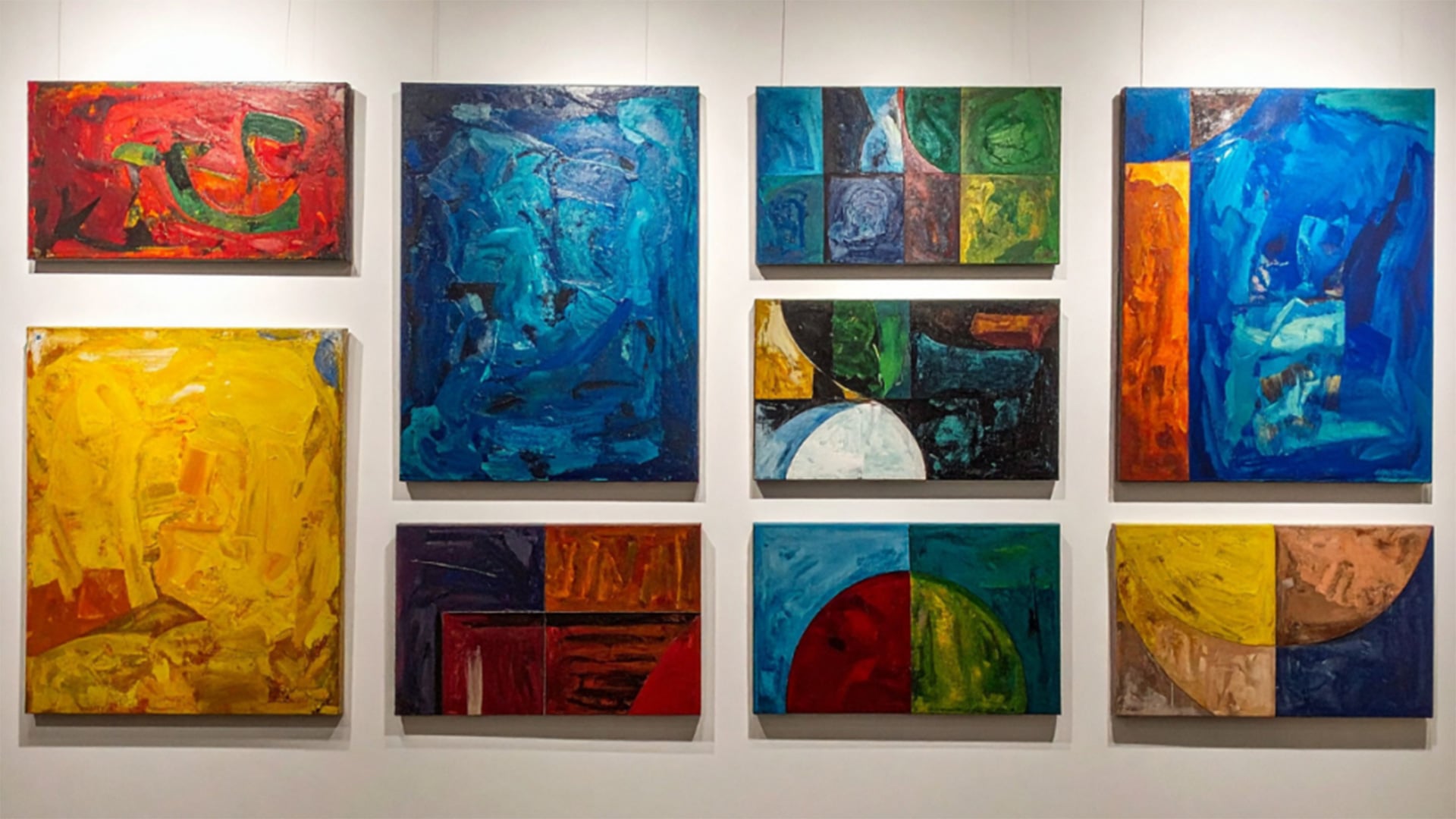 Colorful abstract paintings displayed on a white gallery wall
