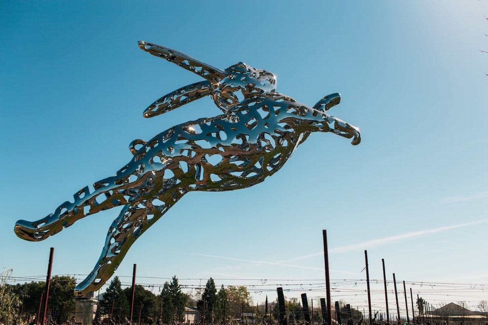 Metal rabbit sculpture against clear blue sky.
