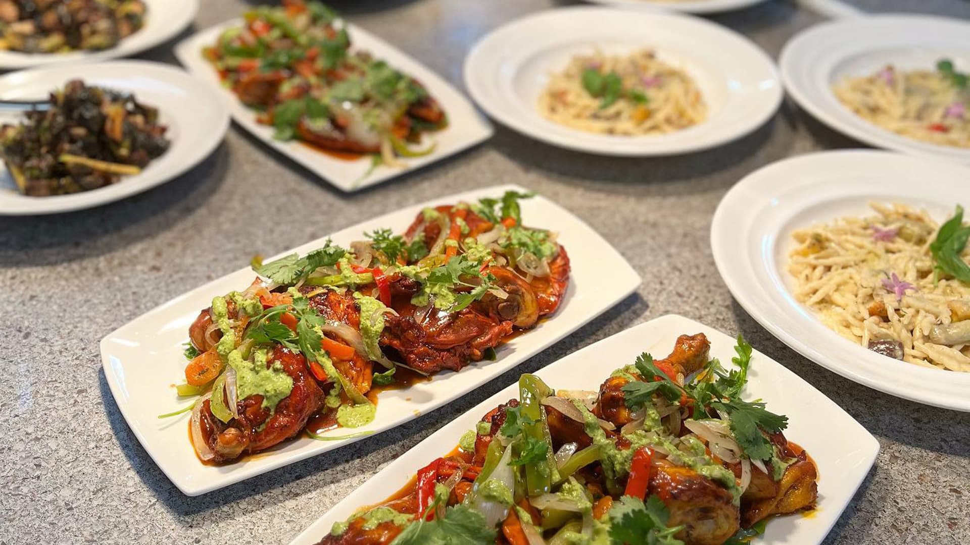 Plates of colorful, flavorful gourmet dishes on a table.