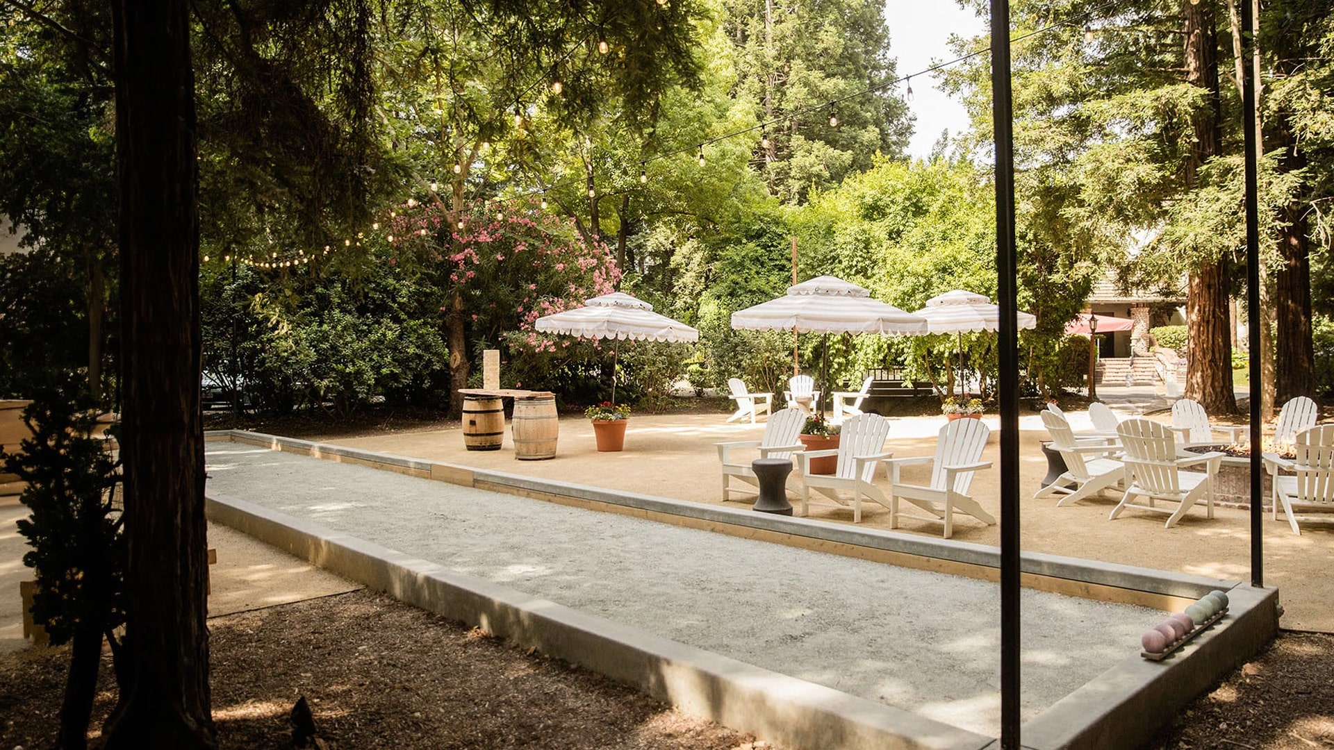 Outdoor seating area with umbrellas and bocce court.